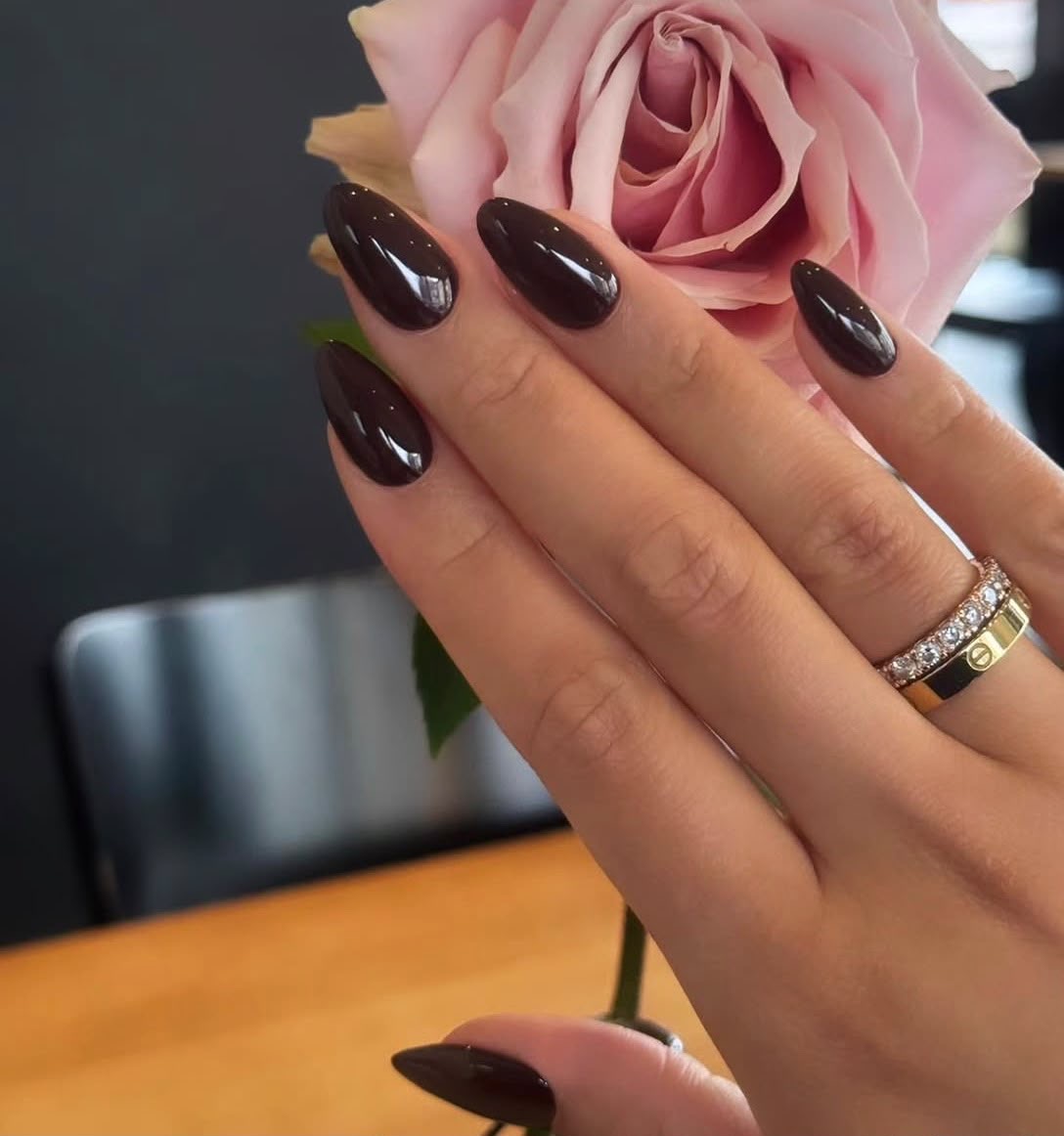 Braune mandelförmige Nägel mit Rosendetails